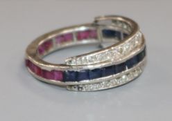 A white metal, diamond, ruby and sapphire swivel triple ring, size M/N.