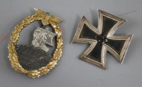 A German Iron Cross first class pin numbered and Naval auxiliary cruiser badge marked RS