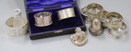 Eight assorted napkin rings including silver and three other items.