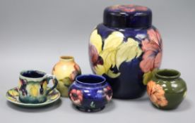 A Moorcroft cup and saucer, three vases and a lidded jar