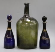 An 18th century large glass bottle and a pair of Bristol blue glass decanters, 'Hollands' and '