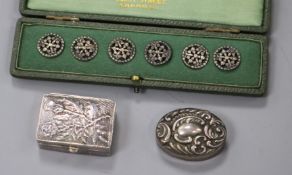 An Edwardian silver pill box, a modern silver pill box and a cased set of six white metal buttons