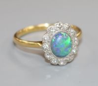 An 18ct gold and platinum, black opal and diamond cluster oval ring, size L.