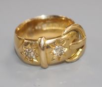 An early 20th century 18ct gold and two stone diamond buckle ring, size N.