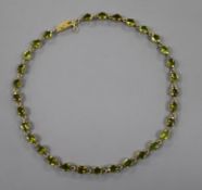 A mid 20th century gilt white metal and oval cut peridot set necklace, 40.5cm.