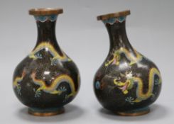 A pair of Chinese cloisonne squat bottle shaped vases, decorated with dragons amid scrolls, on a