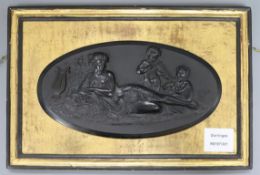 A Victorian pressed composition oval plaque, depicting a muse and two putti with musical