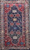 A Caucasian rug, the centre woven in bright colours with geometrical medallions on a blue ground