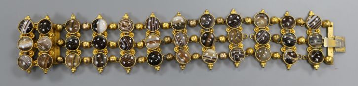 An ornate Victorian pinchbeck and triple row banded agate bracelet, set with thirty six stones,