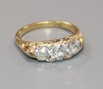 An 18ct gold and three stone diamond ring, with diamond set spacers, size N.