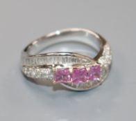 A modern white metal, diamond and pink gem set dress ring, size N.