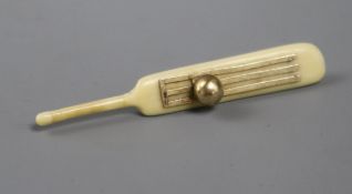 A yellow metal mounted ivory pendant modelled as a cricket bat with stumps and ball, 54mm.