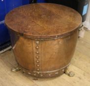 A copper two handled cylindrical log cauldron, on lion's feet, with oak cover, diameter 1ft 10in.