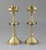 A pair of Gothic revival brass candlesticks, each on circular conical foot with knopped stems