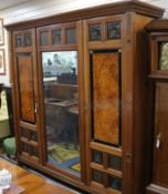 A large Victorian Aesthetic movement walnut wardrobe, manner of Bruce Talbert with mirror door to