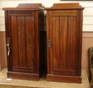 A pair of mahogany pedestal bedside cupboards, each with raised panel to the top and with single