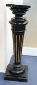 An ebonised and parcel gilt statuary pedestal, with rectangular top, on turned and reeded support