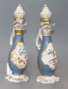 A pair of Paris pear shaped ewers and stoppers, painted with panels of flowers surrounded by gold