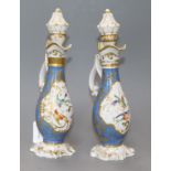 A pair of Paris pear shaped ewers and stoppers, painted with panels of flowers surrounded by gold