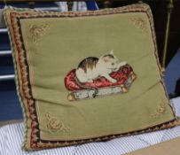 A rectangular cushion, the cover embroidered in petit point with a cat seated on a key pattern