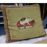 A rectangular cushion, the cover embroidered in petit point with a cat seated on a key pattern