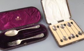 A cased set of six George V silver bean end coffee spoons and a cased christening spoon and fork (