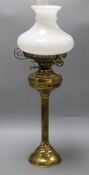 A Victorian brass reeded column oil lamp, on circular foot, with compressed spherical reservoir