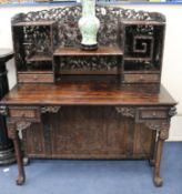 A late 19th century/early 20th century carved Chinese hardwood desk, carved in the round with bamboo