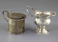 An Edwardian silver baluster cream jug, Chester 1909 and a silver drum shaped mustard pot.