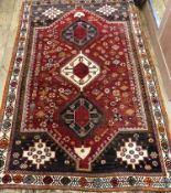 A Shirvan red ground geometric rug, centred by three medallions, with all-over geometric patterning,