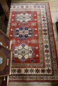 A Hamadan red ground rug, centred by a row of three lozenges, with foliate border, 241cm x 155cm