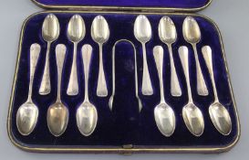 A cased set of twelve Victorian silver Hanovarian rat tail pattern teaspoons, and matching tongs,