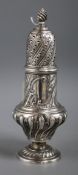 A late Victorian silver sugar caster, of wrythen pedestal urn form with conforming finial, London