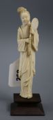 A Chinese carved ivory figure of a lady, standing holding a mirror, on later wooden plinth base,