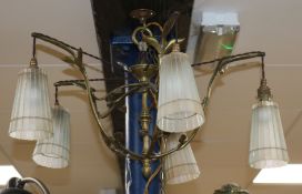 An Art Nouveau brass five light chandelier, of open work scrolling foliage form, with frosted