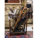 A stained beech umbrella stand, on turned supports with metal tray, together with a collection of