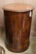 A mid 19th century mahogany cylindrical commode, with lifting top and two doors and covered section,