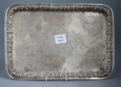 A Persian white metal rectangular tray, engraved and embossed with foliage, birds and figures,