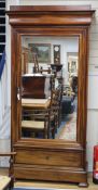 A Charles X mahogany wardrobe, with moulded cornice, fitted mirror panelled door and base drawer, on