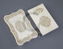 Two Chinese export ivory card cases, 19th century, each carved with figures amid pavilions and