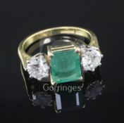 A modern 18ct gold, emerald and diamond three stone ring, with an approximate total diamond weight
