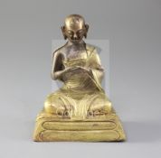 A Chinese gilt copper seated figure of a luohan, probably Qing dynasty, the figure seated on a