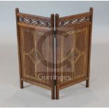 A Victorian Gothic revival inlaid oak small two fold fire screen, with pierced fret friezes, the