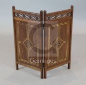 A Victorian Gothic revival inlaid oak small two fold fire screen, with pierced fret friezes, the