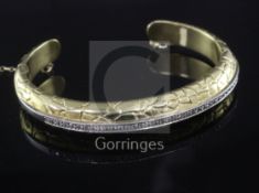 A 1980's Italian Gucci 18ct gold and diamond set 'crocodillo' open bangle, with central row of