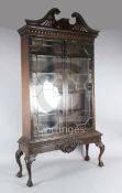 A Chippendale revival mahogany bookcase, with pierced swans neck pediment and floral carved astragal