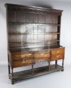 A George III oak dresser, with three shelf rack and five long drawers over a pot board, W.6ft 3in.