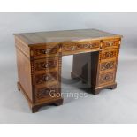 A late Victorian mahogany and marquetry pedestal writing desk, with leather inset top, fitted nine