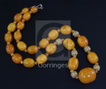 A single strand graduated amber bead necklace, with amber and pierced metal spacers, gross 79 grams,