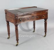 An early Victorian mahogany rectangular writing desk, with lifting central panel to the sloping top,